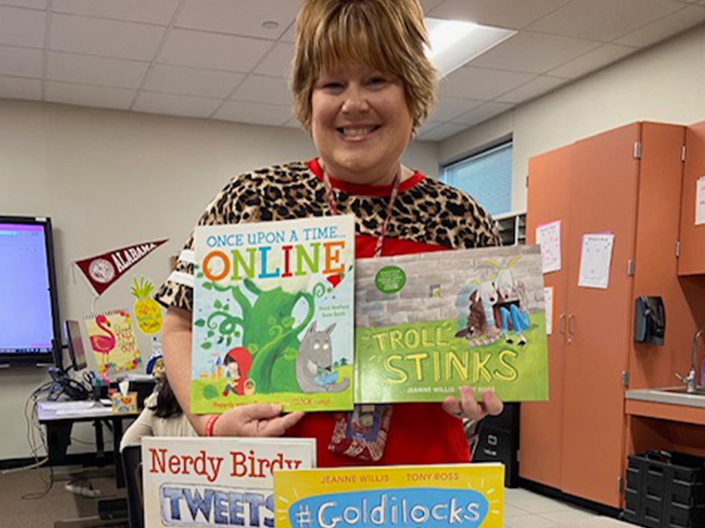 Melissa smiling and holding four picture books.
