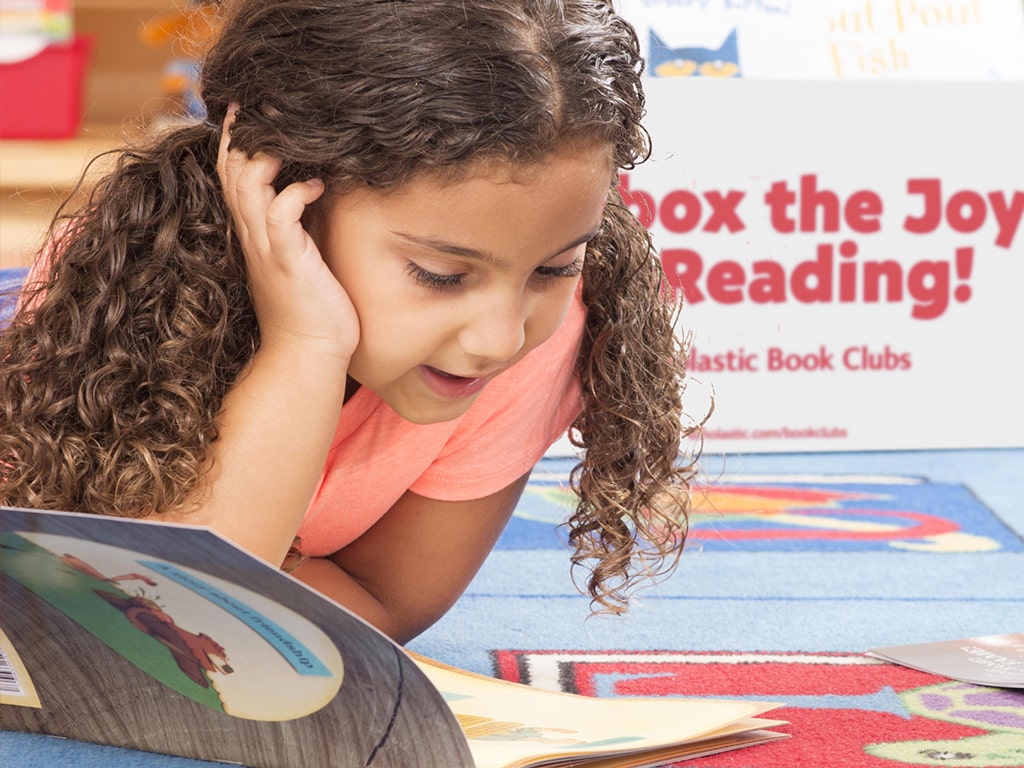 Girl reading aloud a picture book.