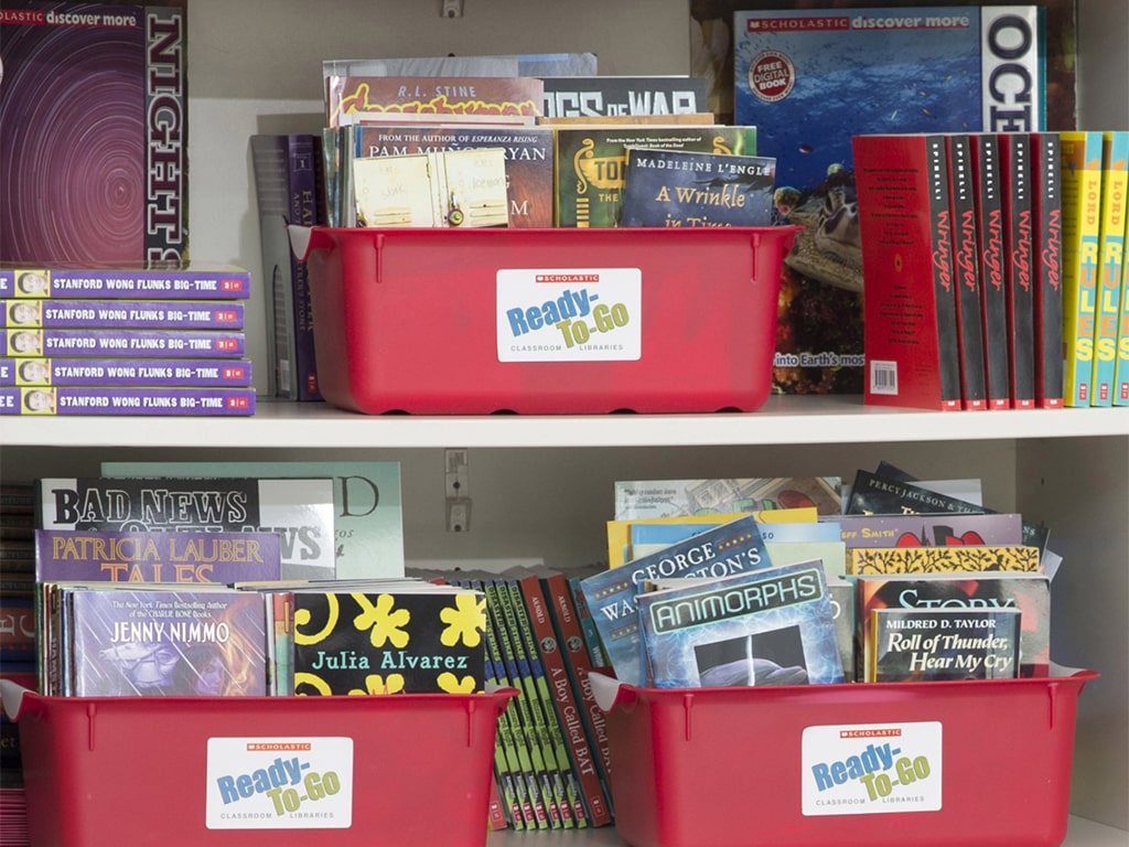 Bookshelves and Scholastic Ready-To-Go book bins filled with books.