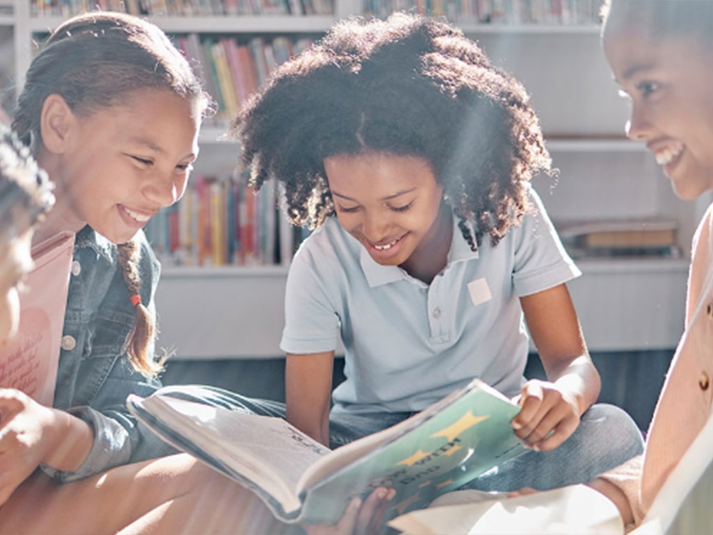 Girl reading a book with friends.