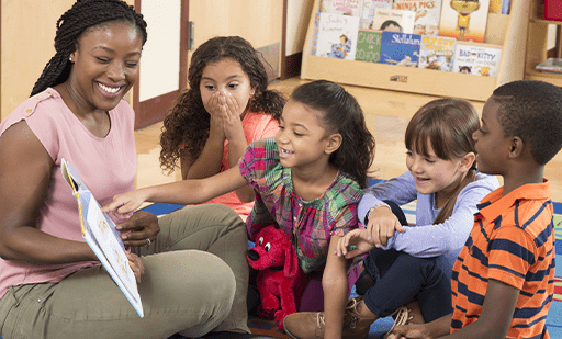 Educator reading a picture book with group of students.